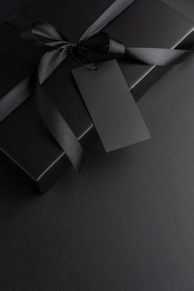 A black gift box with a silk ribbon